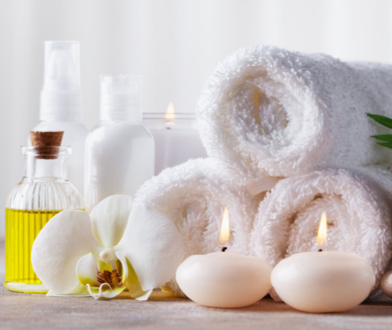 Spa, beauty treatment and wellness background with massage pebbles, orchid flowers, towels, cosmetic products and burning candles. Spa, beauty treatment and wellness background with massage pebbles, orchid flowers, towels, cosmetic products and burning candles. Copy space for text.